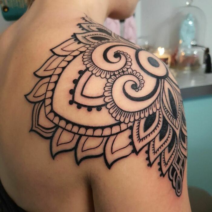 Geometric tattoo with intricate patterns on a person's shoulder, showcasing creativity and style.