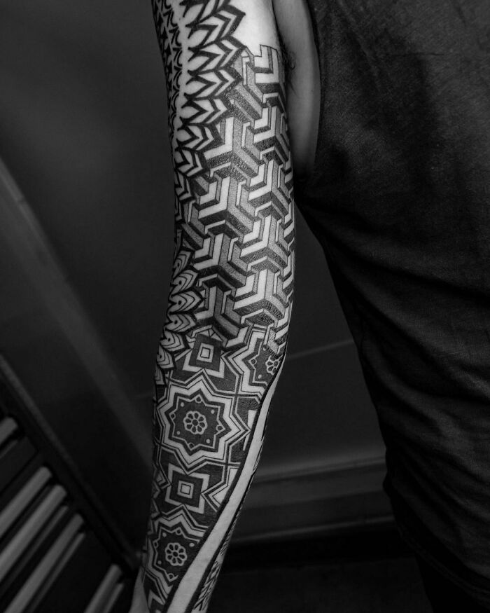 Black and white geometric tattoo sleeve showcasing intricate shapes and forms.
