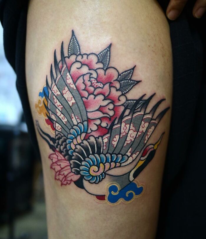 Colorful tattoo of a bird with floral elements by a Korean artist, showcasing intricate and mesmerizing design.