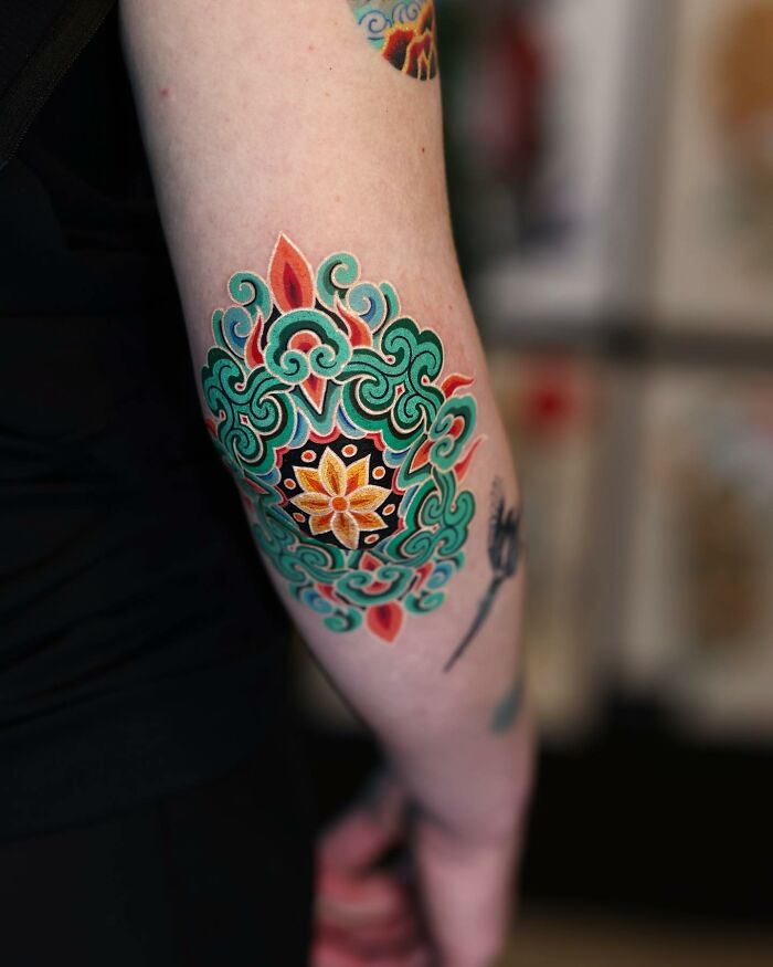 Colorful Korean tattoo design with intricate patterns on an arm.