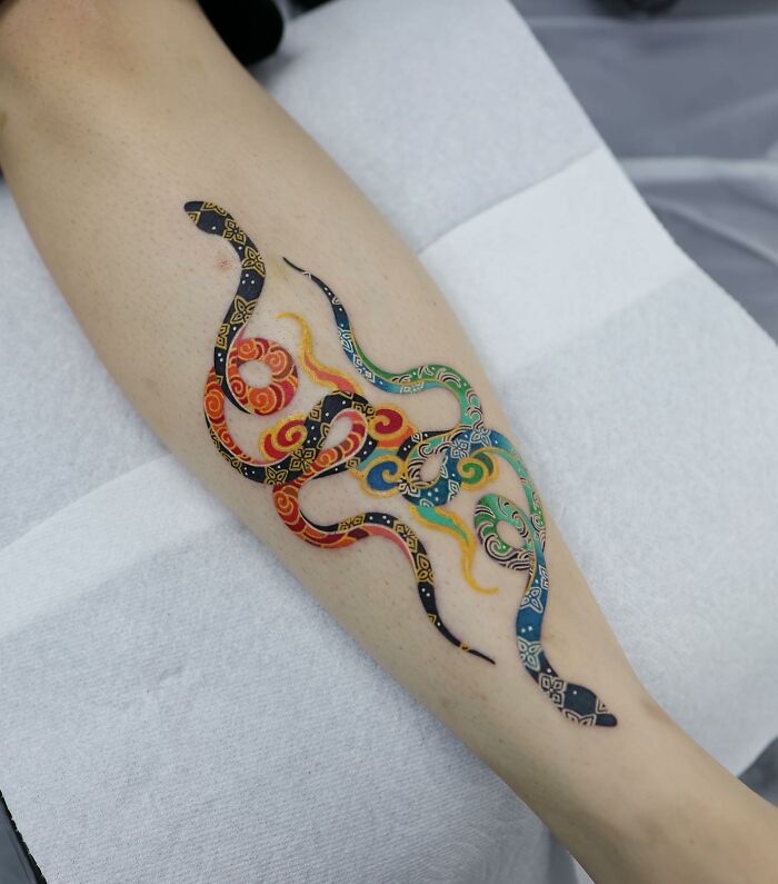 Colorful, mesmerizing tattoo design on a leg by a Korean artist, featuring intricate patterns and vibrant hues.