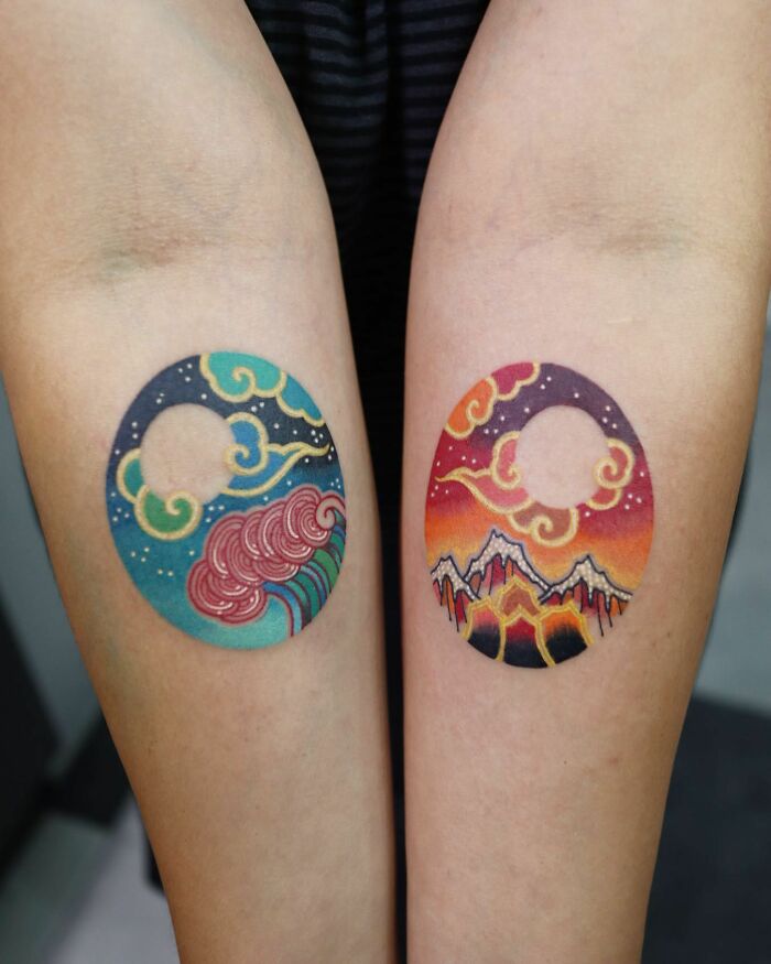 Colorful circular tattoos on forearms by Korean artist, featuring ocean waves and mountains under night skies.