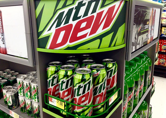 Mountain Dew cans and bottles displayed on store shelves highlighting American cuisine products banned elsewhere.