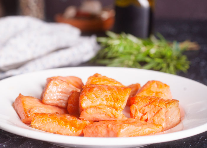 Cooked salmon pieces served on a white plate highlighting controversial American cuisine and seemingly healthy foods.