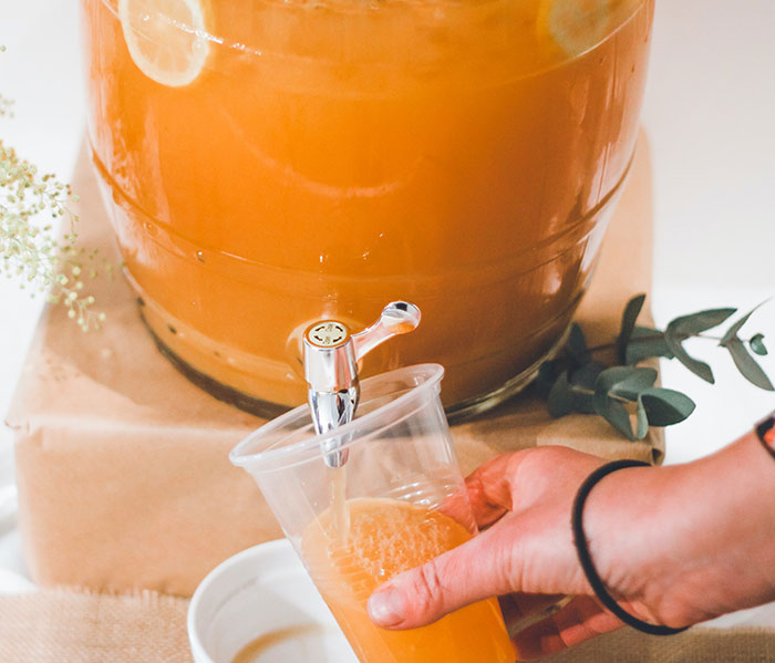 Person pouring juice from a big jug of juice 