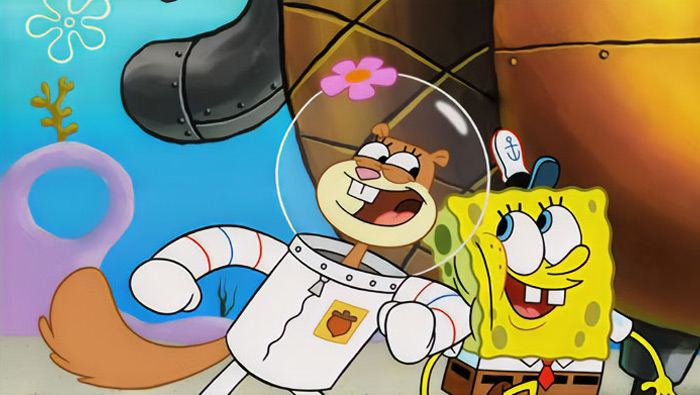 Cartoon couple smiling together underwater, featuring a sponge in a tie and a squirrel in a suit with a helmet.