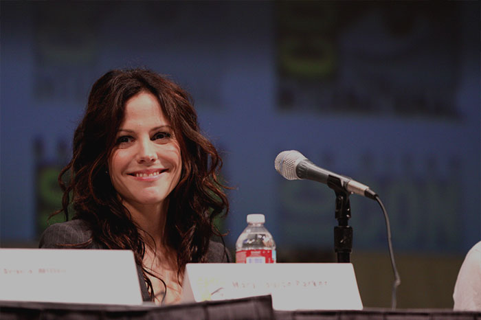 Mary-Louise Parker smiling warmly at a panel discussion, representing celebrities who never married yet found love.
