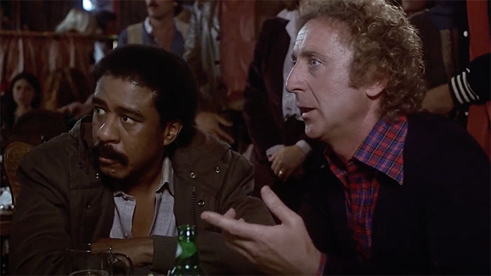Gene Wilder and Richard Pryor sitting and looking in movie Stir Crazy