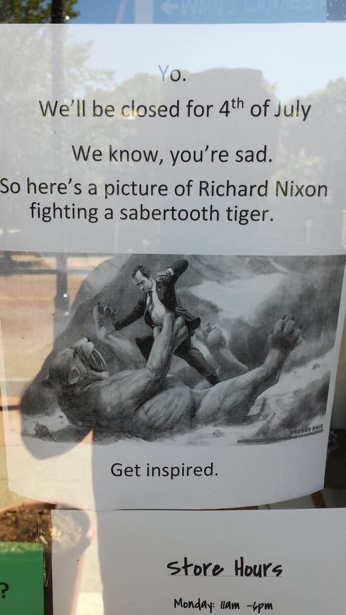 Hilariously absurd sign showing Richard Nixon fighting a sabertooth tiger to cheer people up on July 4th closure.