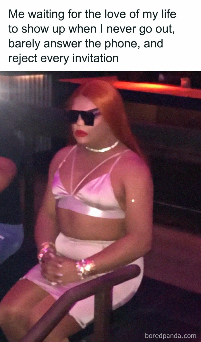 Person in sunglasses and pink outfit sitting alone with text about waiting without going out, an introvert meme concept.