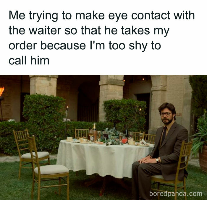Introvert meme showing a shy man sitting alone at a table trying to make eye contact with a waiter to place an order.