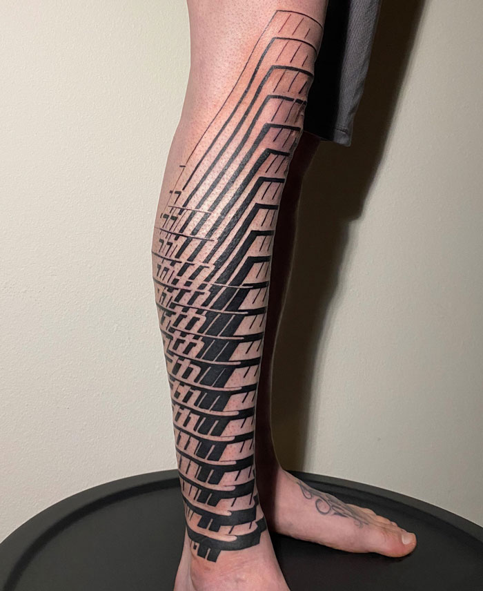 Geometric tattoos on leg showcasing intricate, bold patterns.
