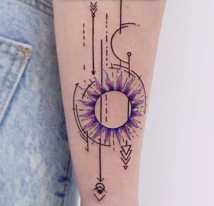 Geometric tattoo design featuring circles, arrows, and abstract forms on forearm, showcasing creative shapes and artistry.