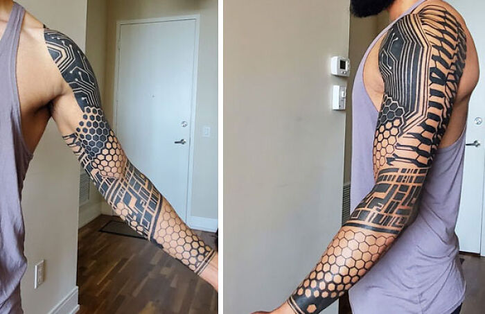 Man with intricate geometric tattoos covering full sleeve, showcasing diverse patterns and creativity.