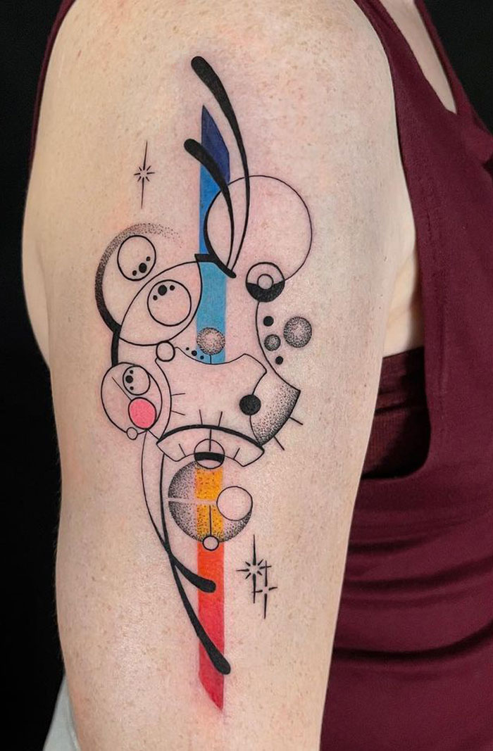 Colorful geometric tattoo design featuring circles and lines on an arm.