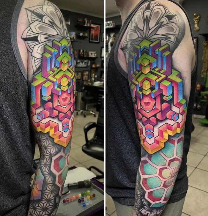 Vibrant geometric tattoo on upper arm, showcasing colorful shapes and intricate design in tattoo studio.