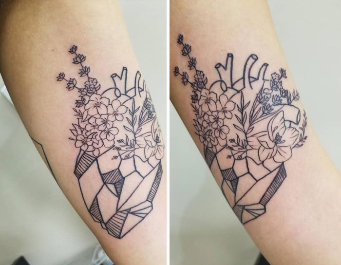 Geometric tattoo of a heart with floral elements, showcasing detailed line work on the forearm.