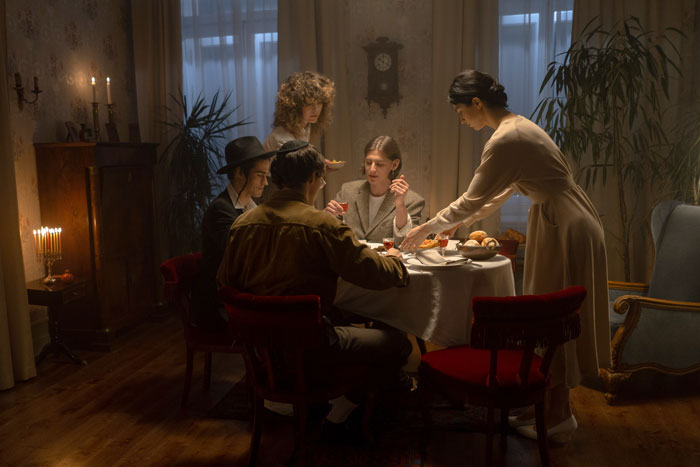 People sitting by the table celebrating Hanukkah at evening