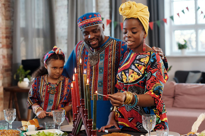 Colorful dressed family lighting the candlesticks