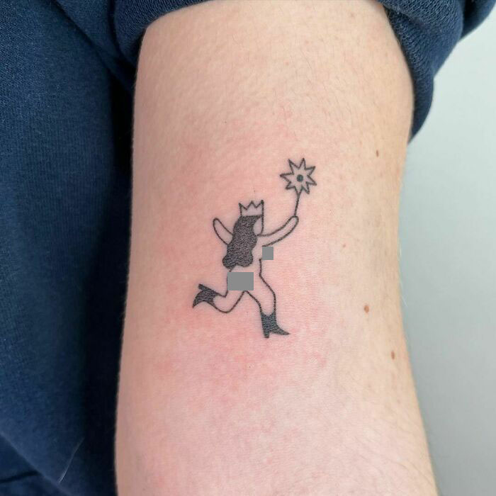 Funny tattoo of a naked princess running with a wand on an arm.