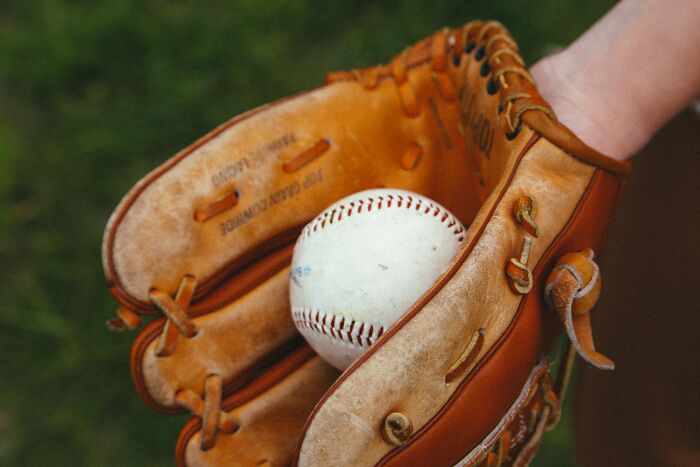 Baseball glove holding a ball, symbolizing 27 people sharing the juiciest pieces of gossip known.