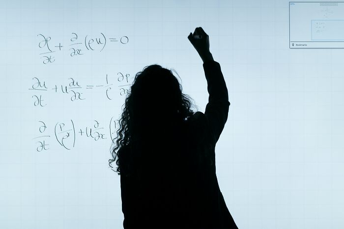 Silhouetted person writing complex equations on a board, illustrating sharing juicy pieces of gossip concept.