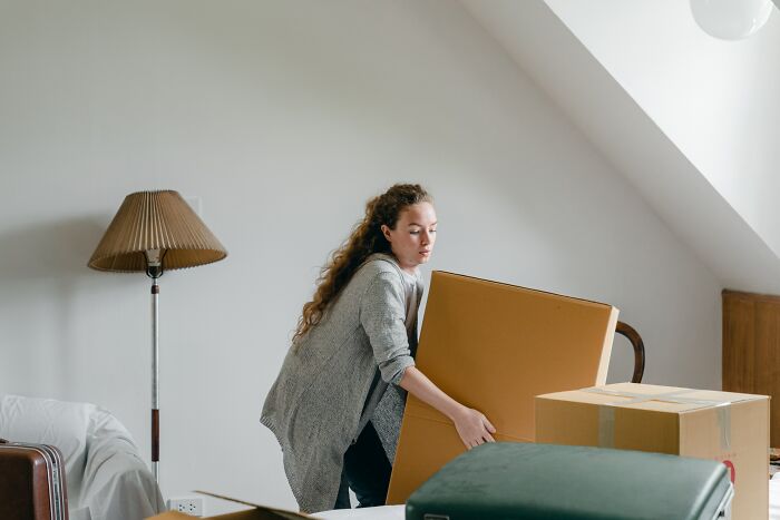Woman Lifting Cardboard Box 