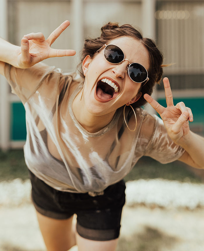 Person smiling and showing signs