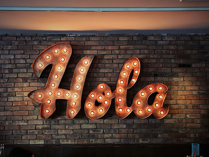 Led 'Hola' sign on the wall made of bricks
