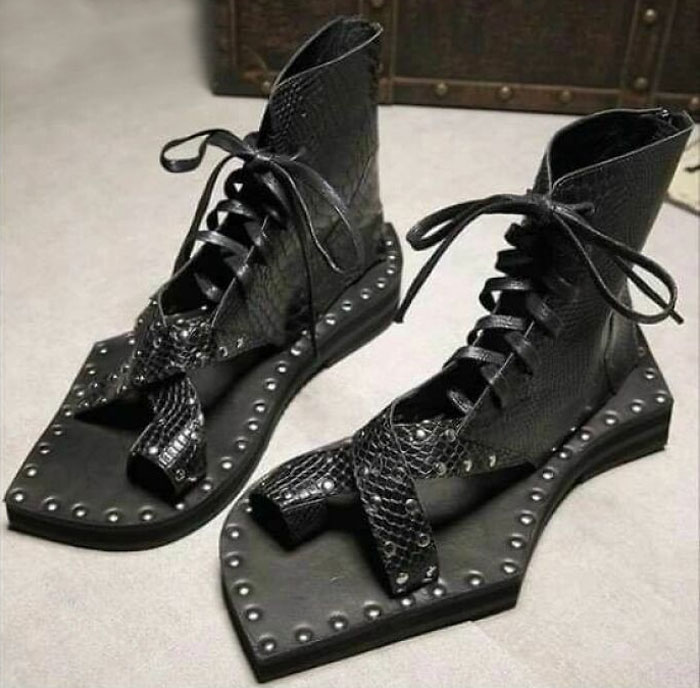 Unusual black shoes with toe cutouts and studded edges, featuring laces and a unique flat design.