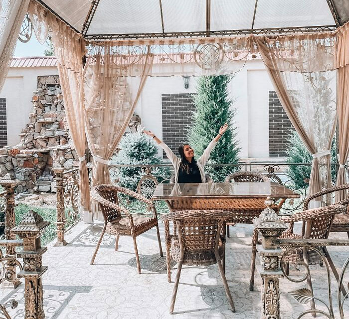 Pergola with wicker furniture and person sitting
