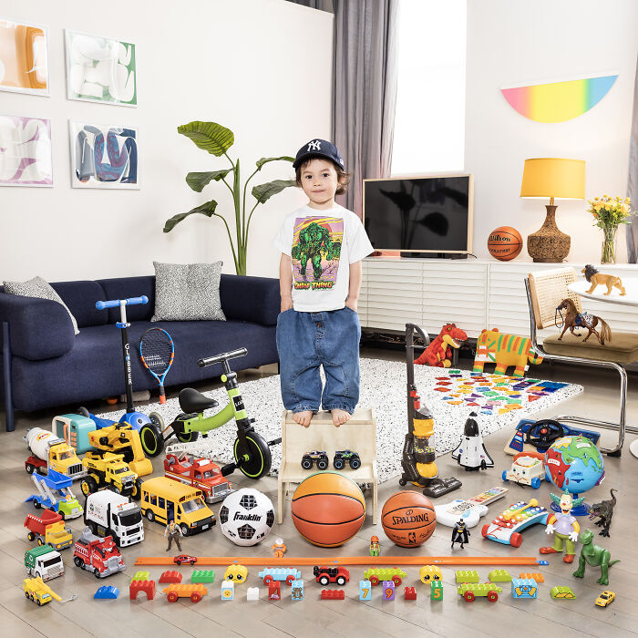 Child standing among a diverse toy collection in a colorful room, showcasing global toy stories and childhood play.