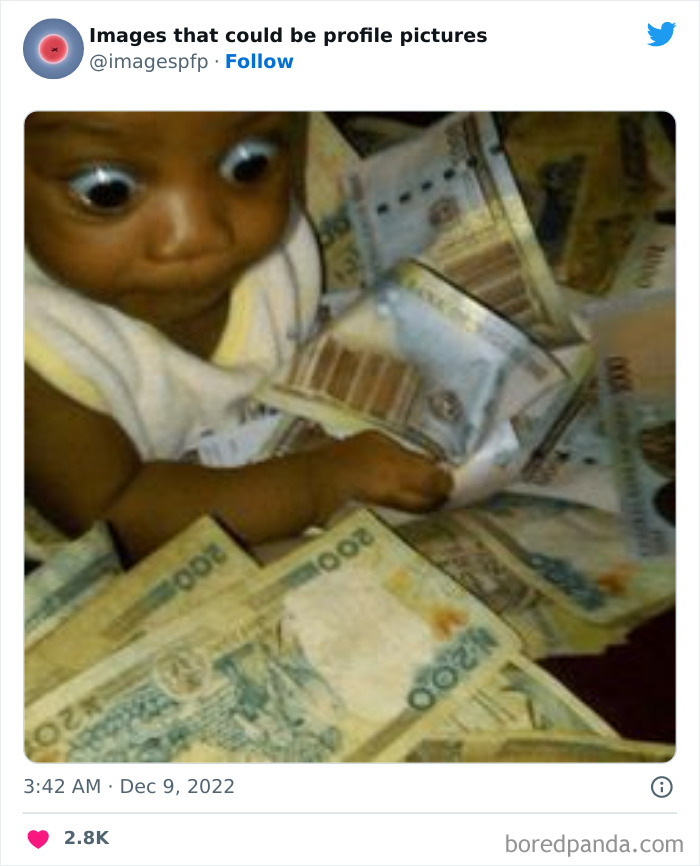 Baby with wide eyes surrounded by and holding various currency bills, a funny and weird profile picture idea.