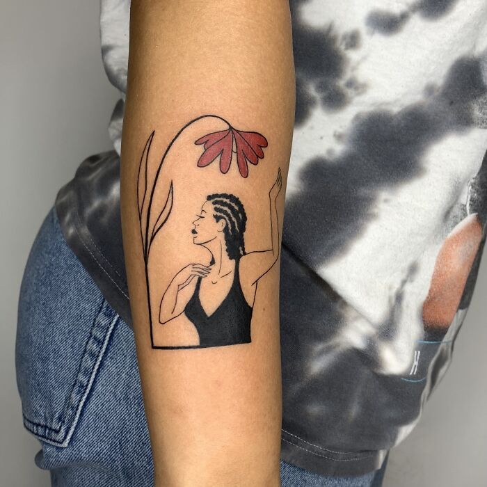Tattoo resembling an illustration, featuring a stylized woman and a flower on a person's forearm.