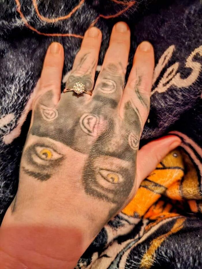 Tattoo on hand with multiple eyes and a ring, illustrating hilariously bad tattoo art.