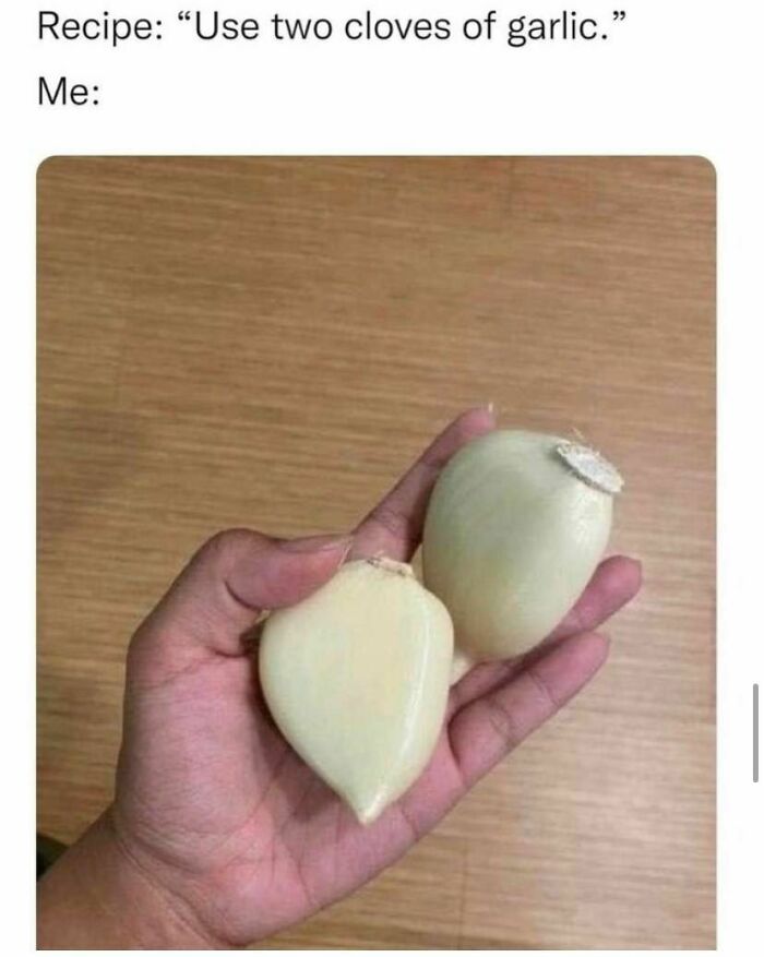 Hand holding two large garlic bulbs, humorously misinterpreting a recipe, embodying relatable meme humor.