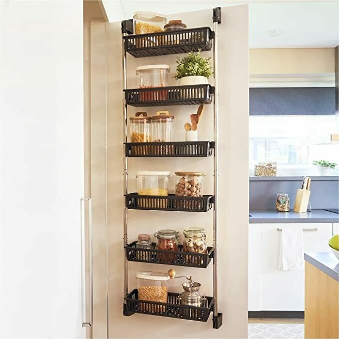 Wall-mounted pantry organizer with multiple shelves holding jars and containers, showcasing home organization ideas.