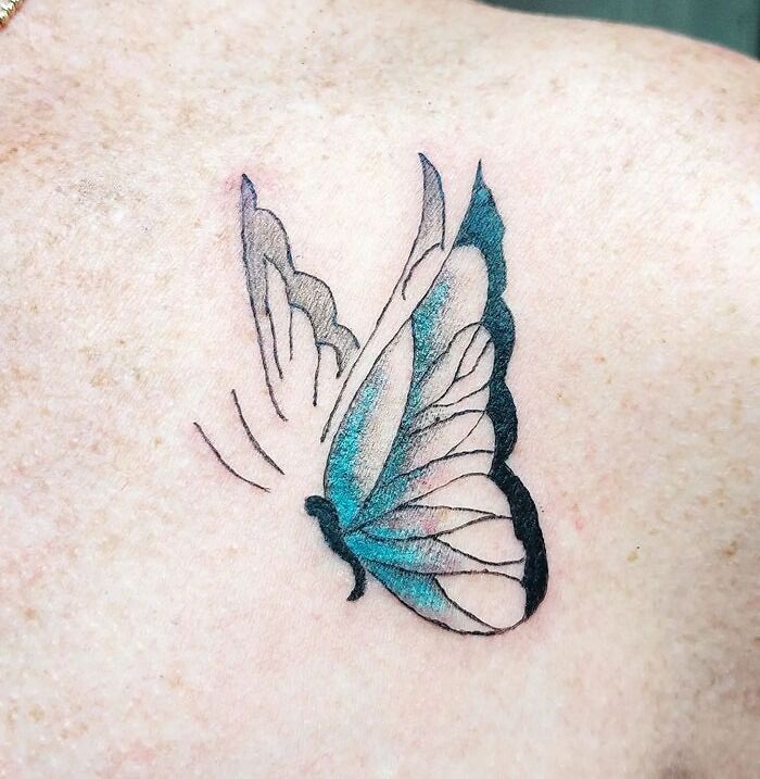 Butterfly animal tattoo with blue and black ink on skin, showcasing creative design ideas.
