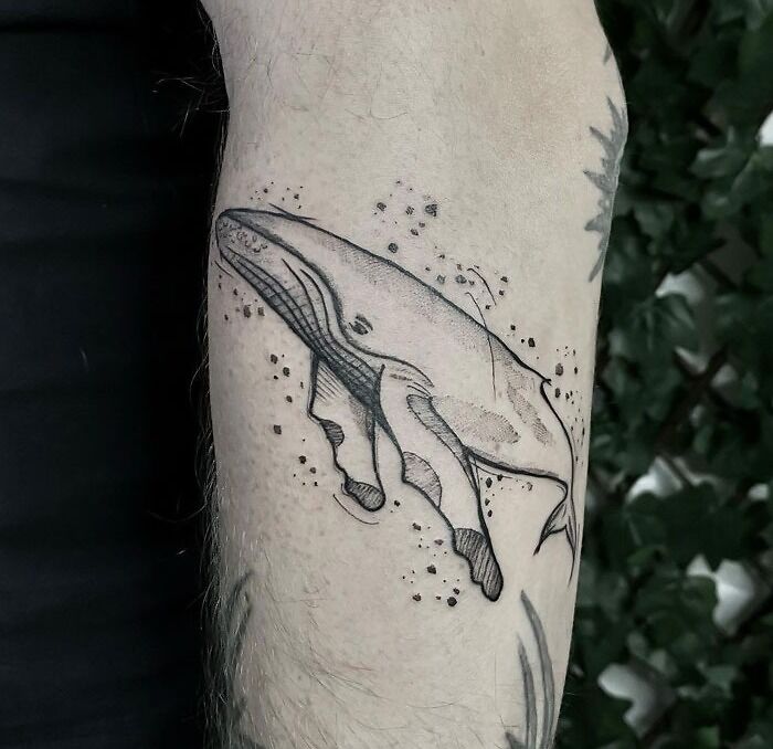 Whale tattoo on forearm, showcasing intricate animal art design.