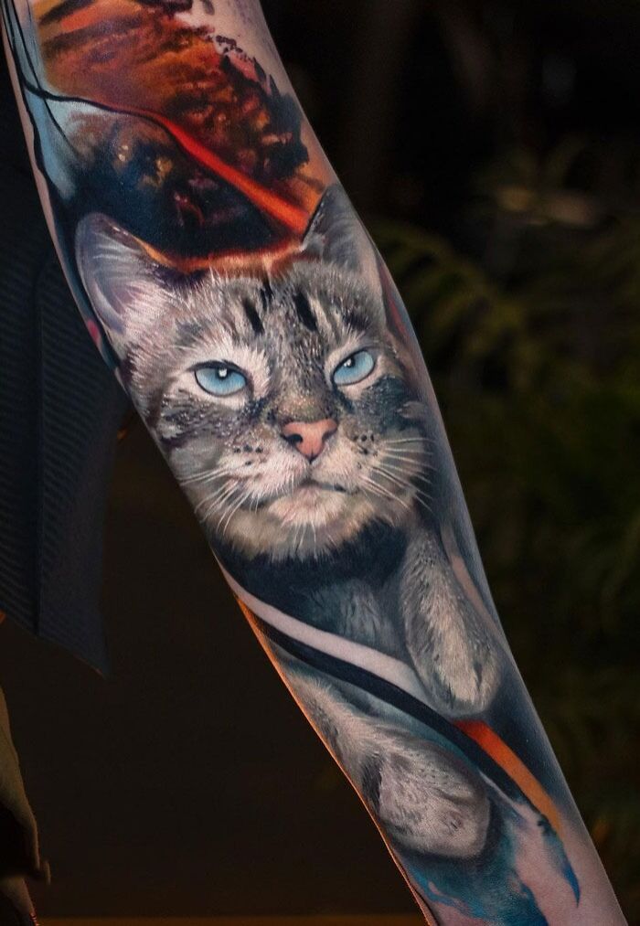 Realistic cat tattoo design on forearm, showcasing vibrant colors and intricate details in an animal-inspired theme.