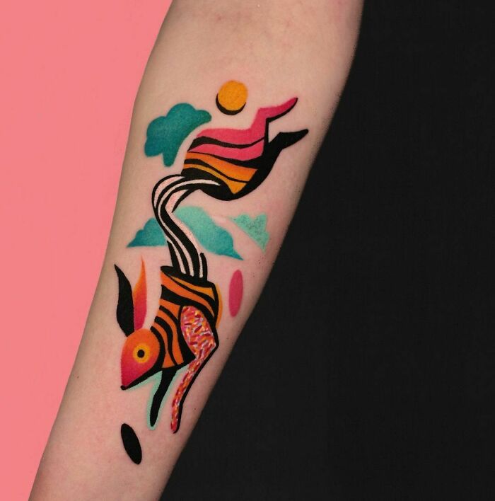 Colorful abstract animal tattoo on forearm featuring vibrant patterns and shapes.