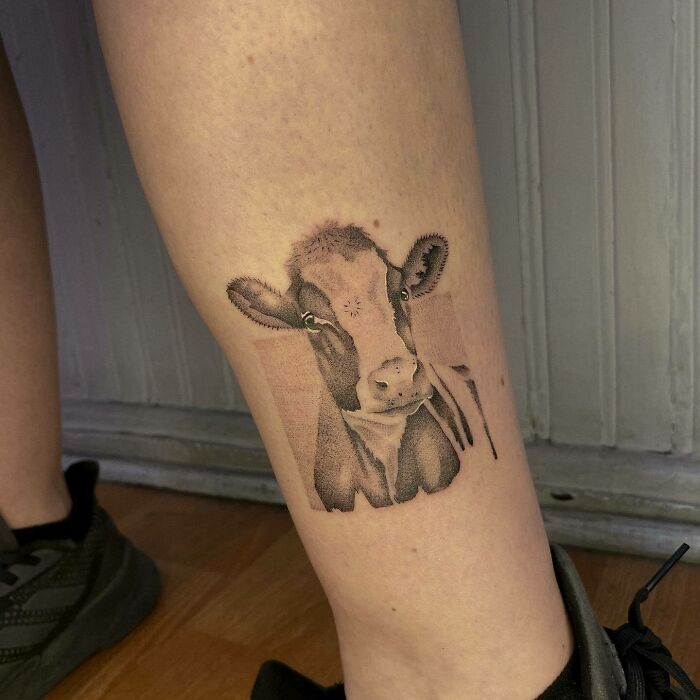 Cow tattoo on leg, showcasing detailed animal design and creative artwork.