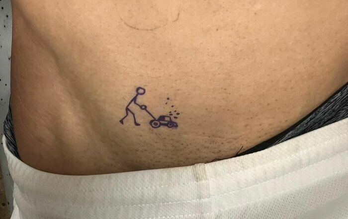Funny tattoo of a stick figure pushing a lawn mower on someone's skin.