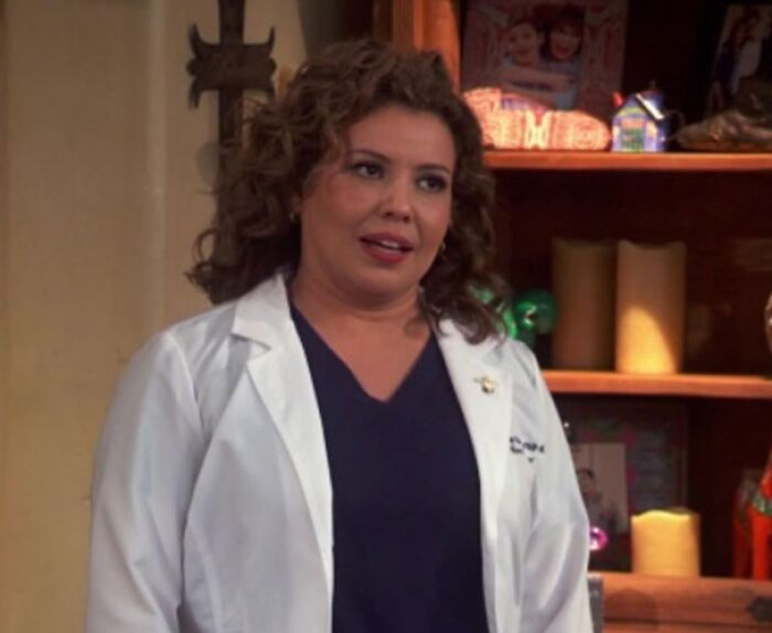 Penelope Alvarez is standing and talking near a bookshelf