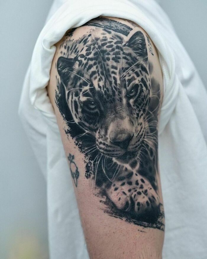 Realistic leopard tattoo with detailed shading on an arm, showcasing tattoo artistry.