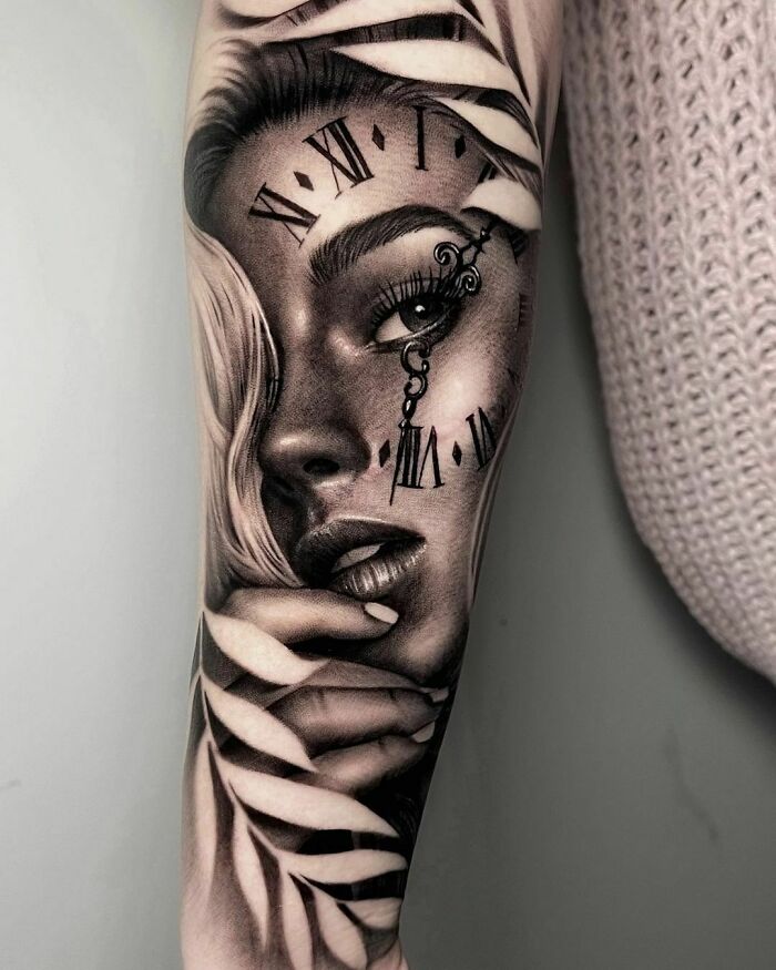 Realistic tattoo of a woman's face with clock elements and leaf details on arm.