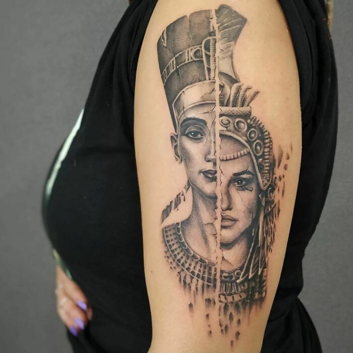 Realistic tattoo on arm showing a split image of two historical figures in black and gray design.