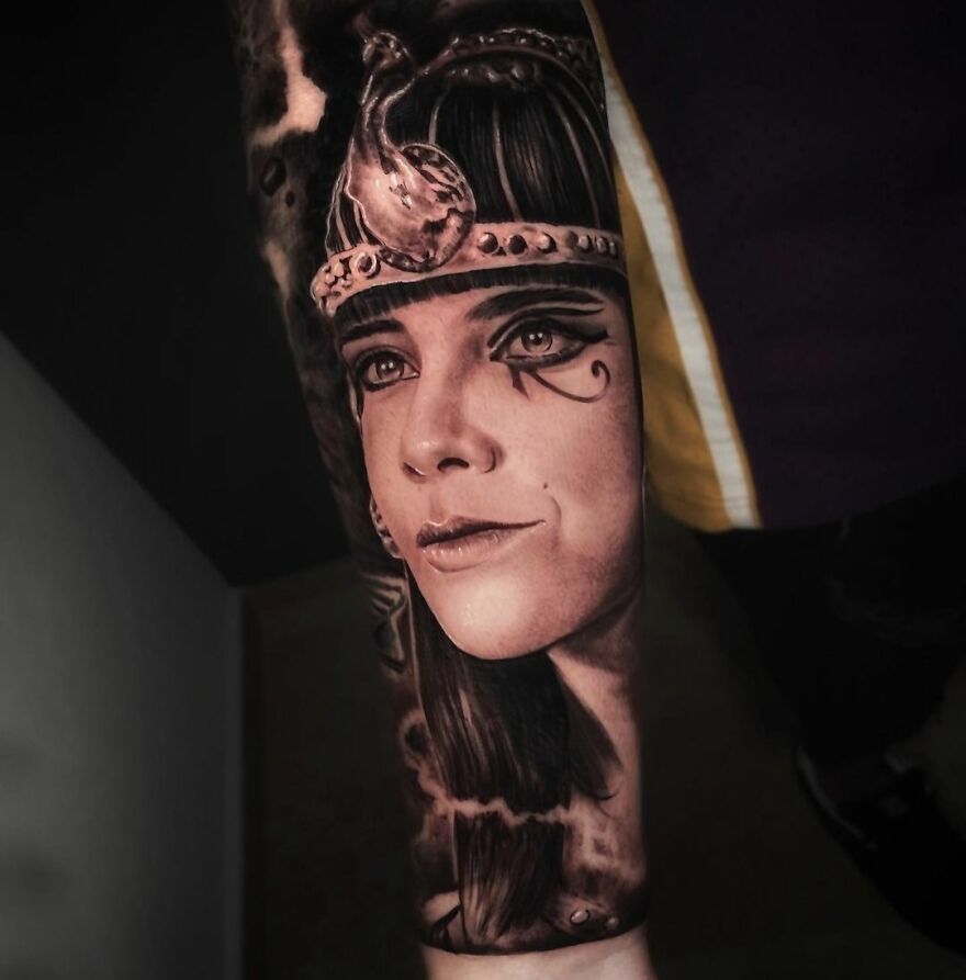 Realistic tattoo of a woman's face with intricate details, resembling ancient artwork.