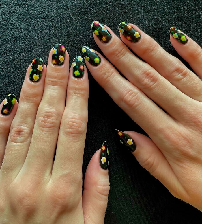 Floral black nail art design with colorful flowers, perfect for your next nail appointment.