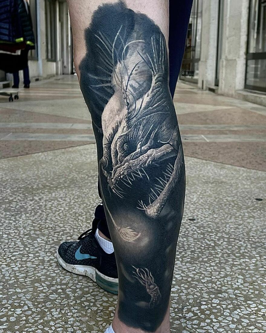 Realistic deep sea anglerfish tattoo on leg with intricate detailing.